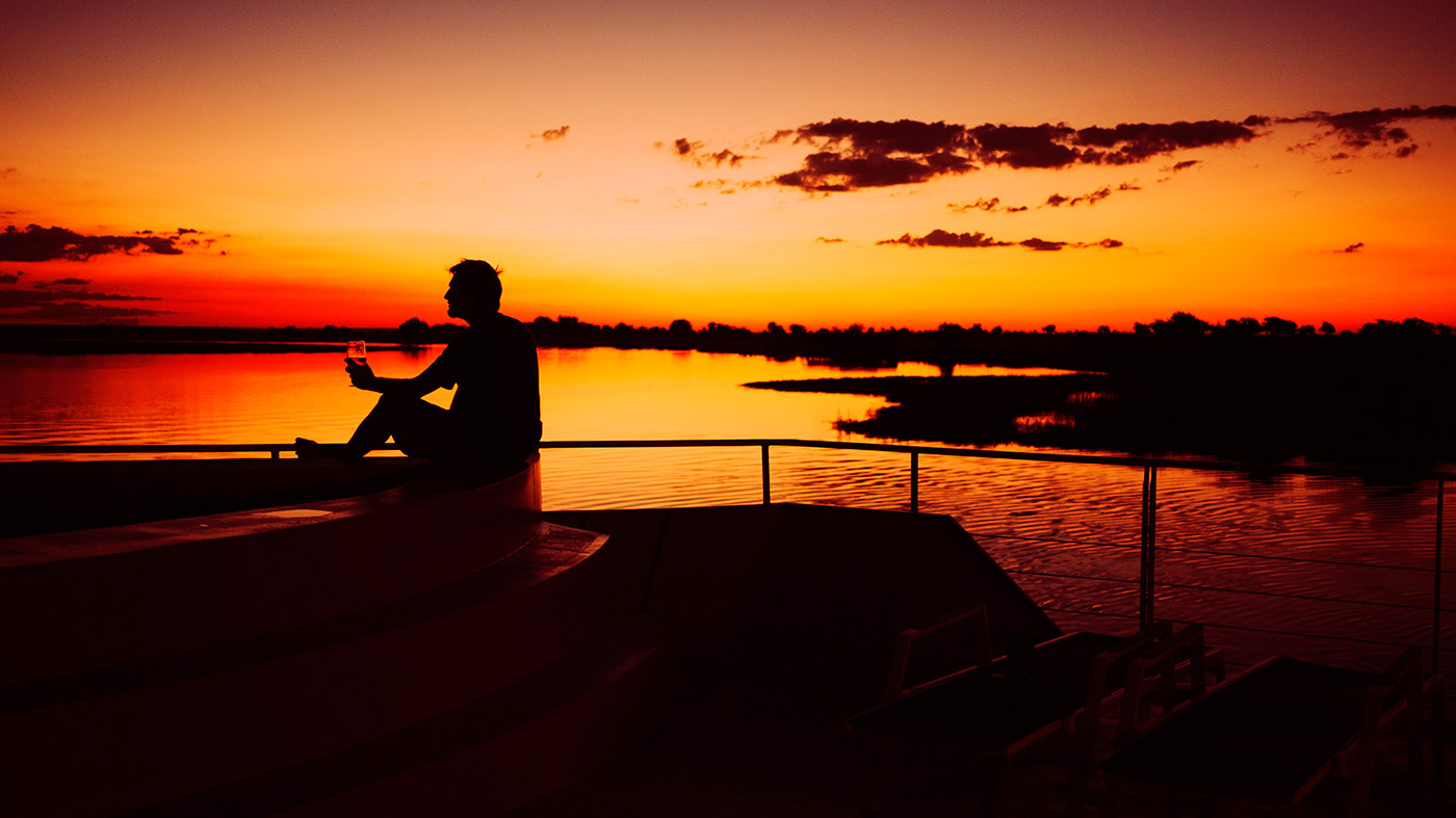 Silhouette of a man enjoying a sunset on the Chobe River, Botswana, Africa