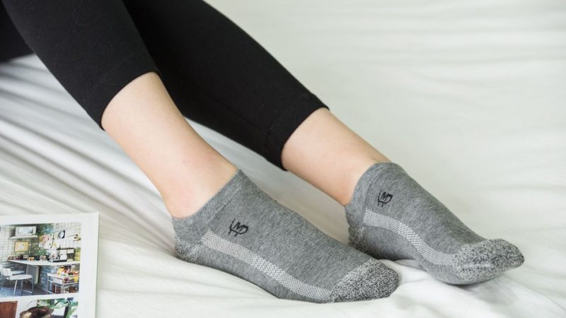 Woman in bed wearing MP Magic Socks